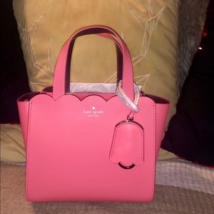 Pink Kate Spade mini bag with shoulder strap.